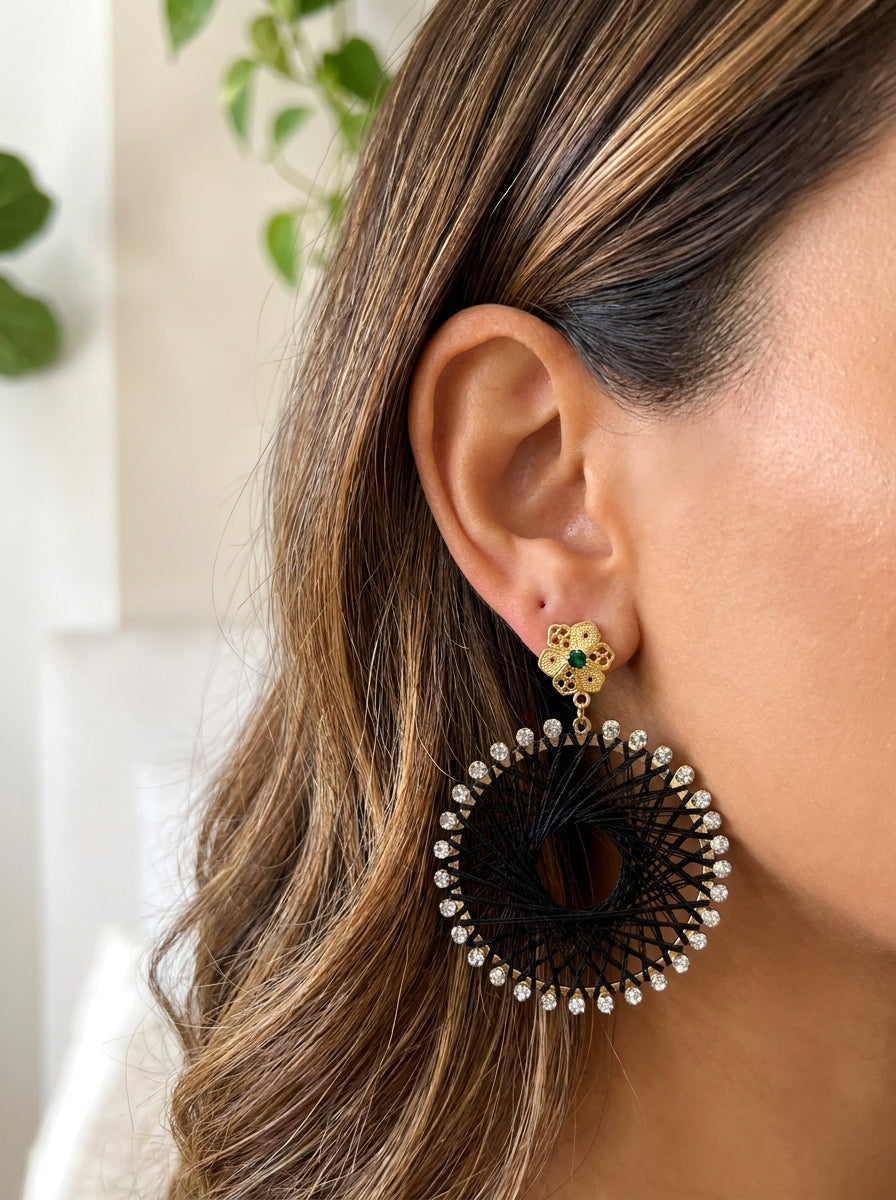 Aretes Flor de Ataraxia Negra GAIAM puestos en la oreja, detalle macro