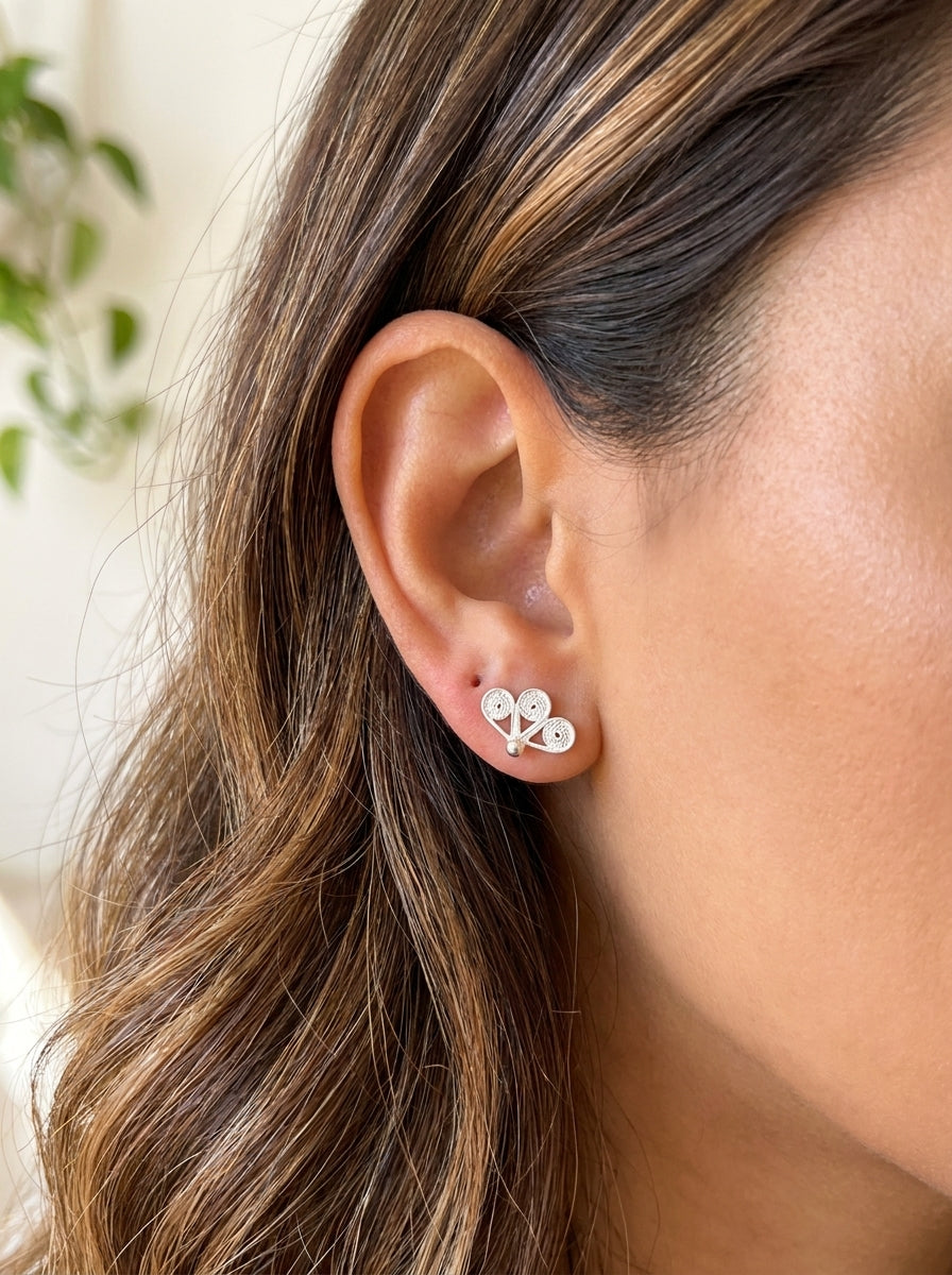 Aretes Trebol GAIAM puestos en la oreja, detalle macro