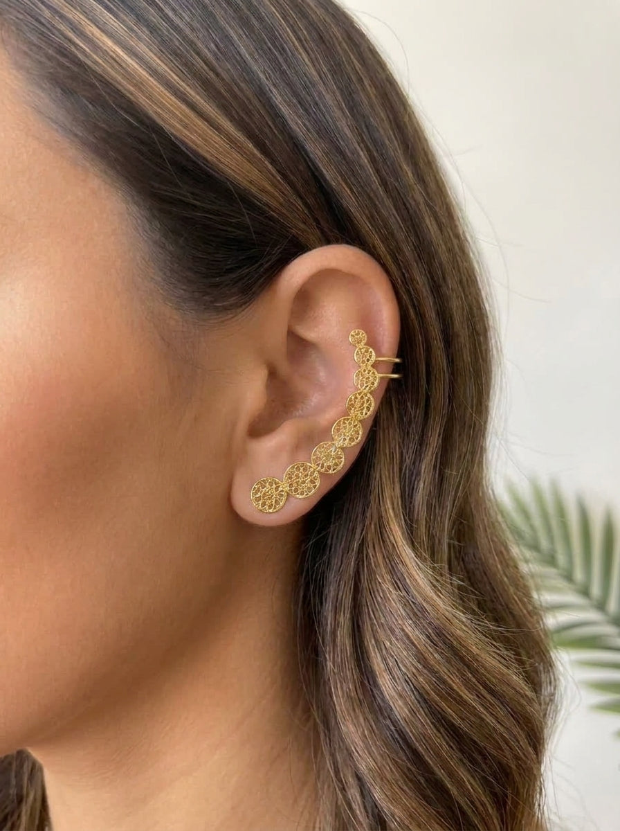 Earcuff Planeta baño de oro 24K GAIAM puesto en la oreja, detalle macro
