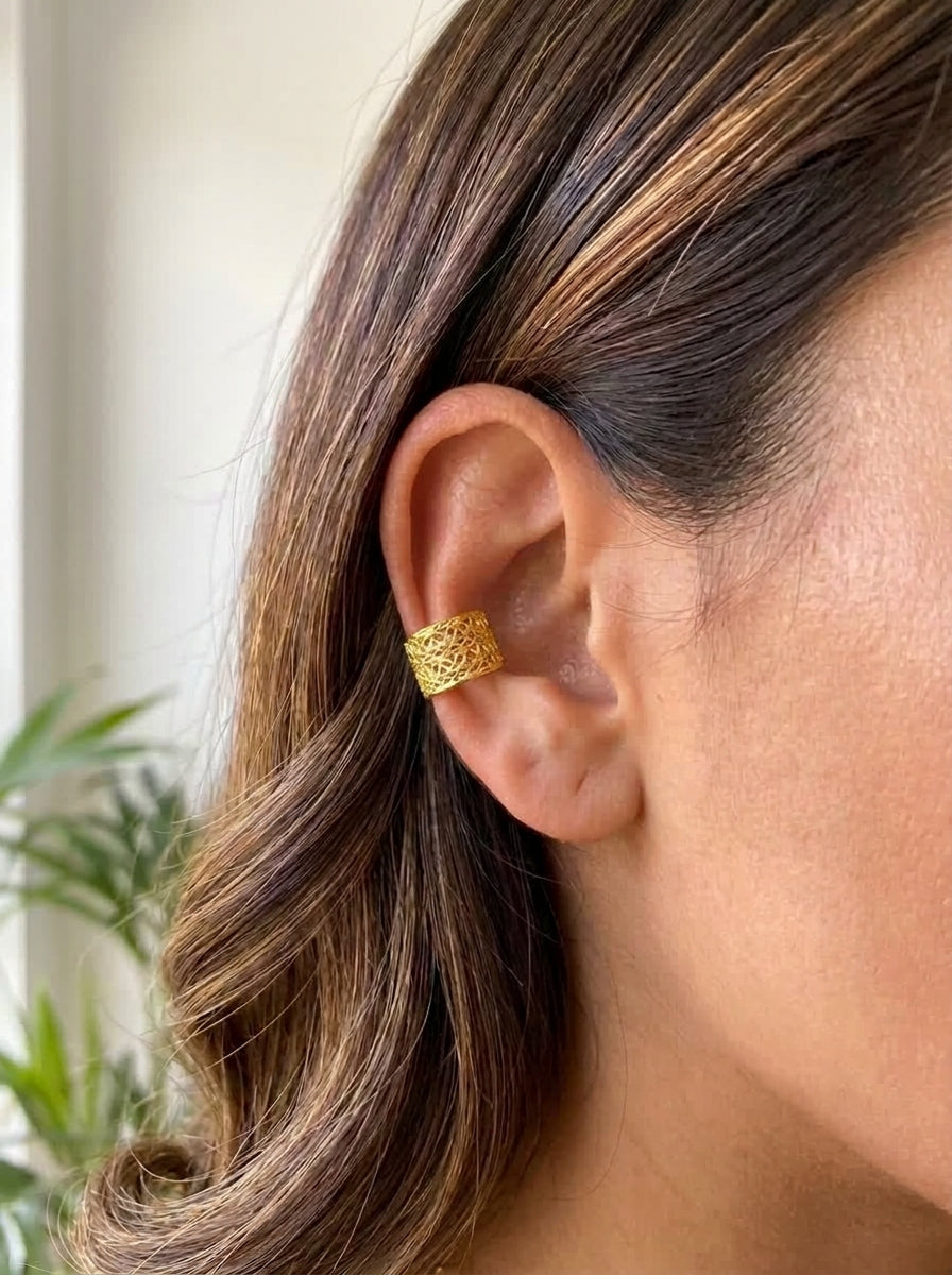 Earcuff Troya baño de oro 24K GAIAM puesto en la oreja, detalle macro